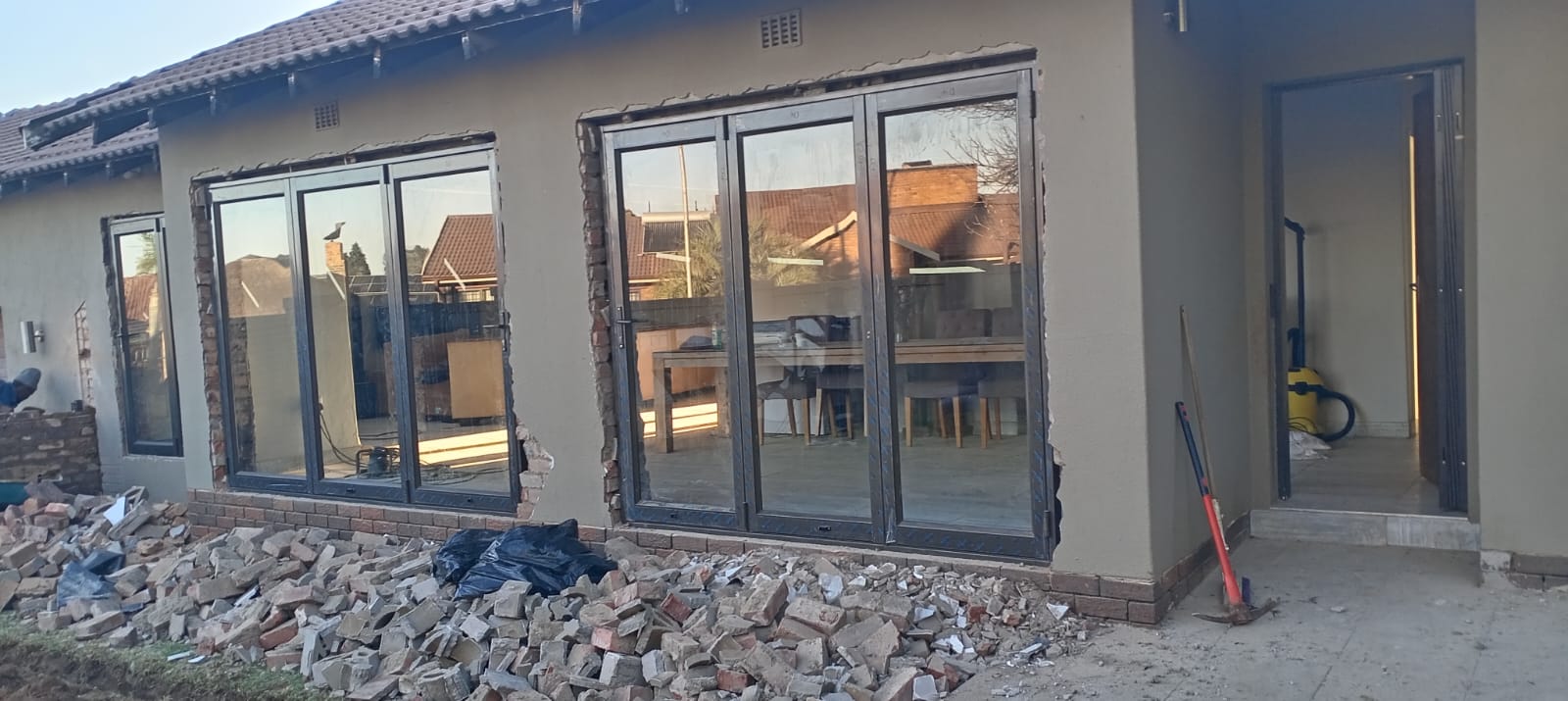 Multiple charcoal aluminium doors and windows installed during a home renovation